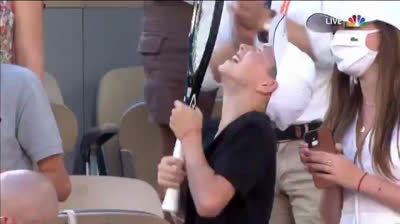Djokovic gives his racquet to a child after winning Roland Garros